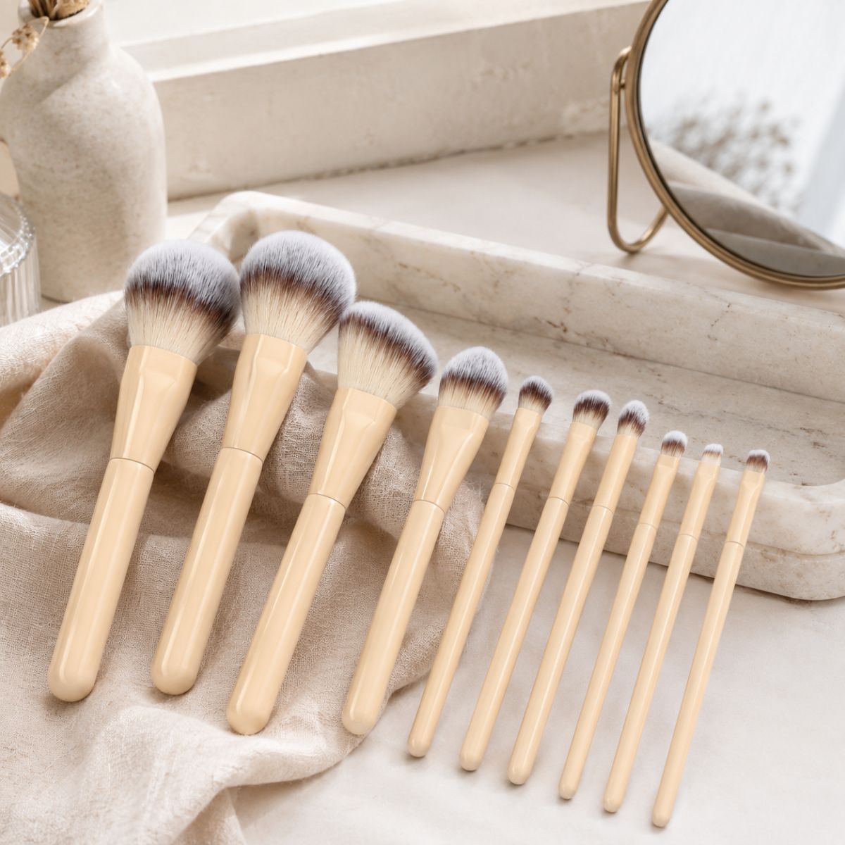 Zehn Make-up-Pinsel mit Holzgriffen und braun-weißen Borsten.