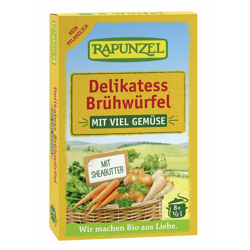 Gelbe Verpackung mit "Rapunzel Delikatess Brühwürfel". Enthält Gemüse, Sheabutter. Text: "Mit viel Gemüse".