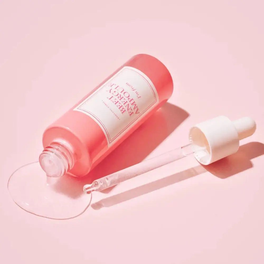Rosa Flasche mit Pipette liegt. Flüssigkeit fließt heraus. Text: BEET ENERGY AMPOULE, I'm from.