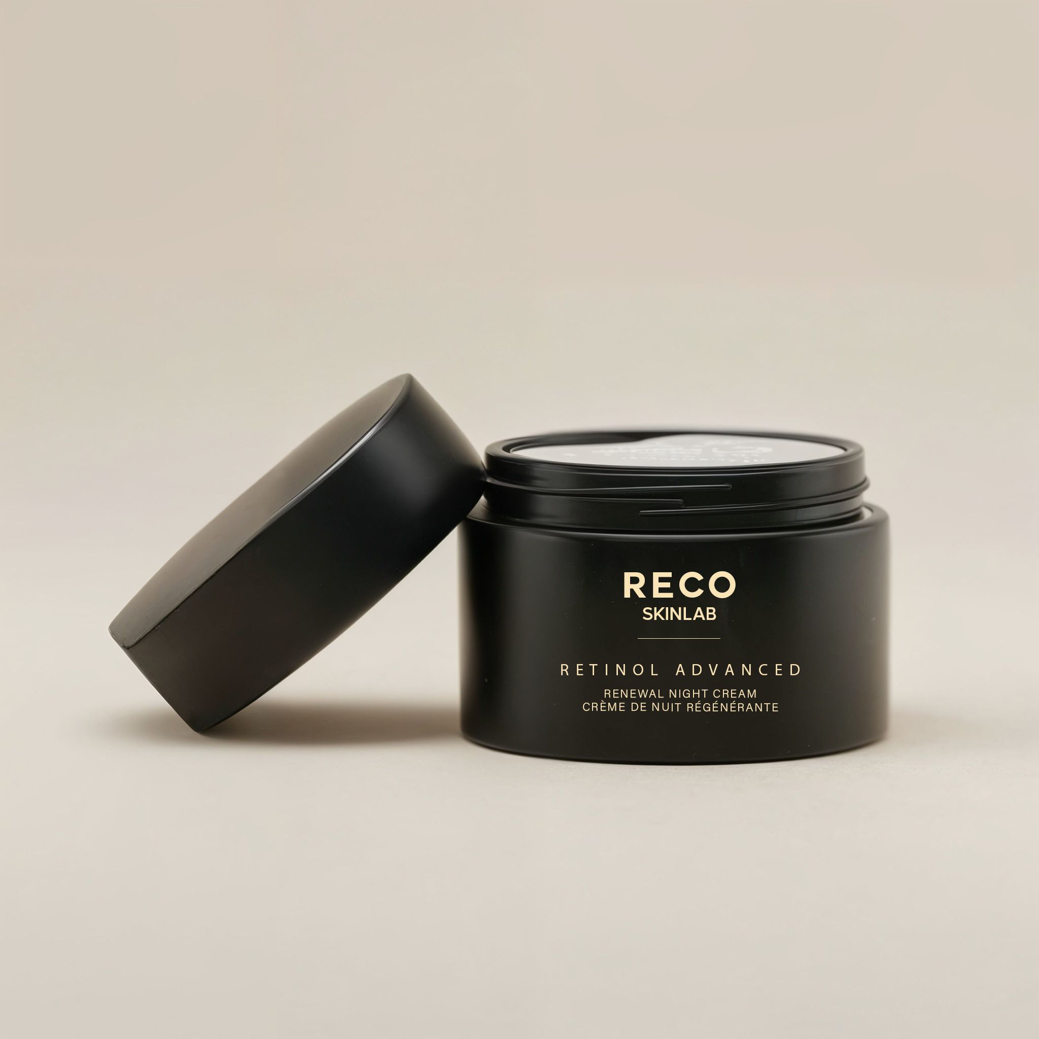 Offener schwarzer Tiegel mit Deckel daneben. Aufschrift RECO SKINLAB, Retinol Advanced Renewal Night Cream, Crème de nuit régénérante.