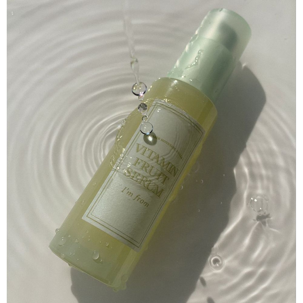 Serumflasche unter Wasser. Aufschrift: Vitamin Fruit Serum, I'm from. Wassertropfen.