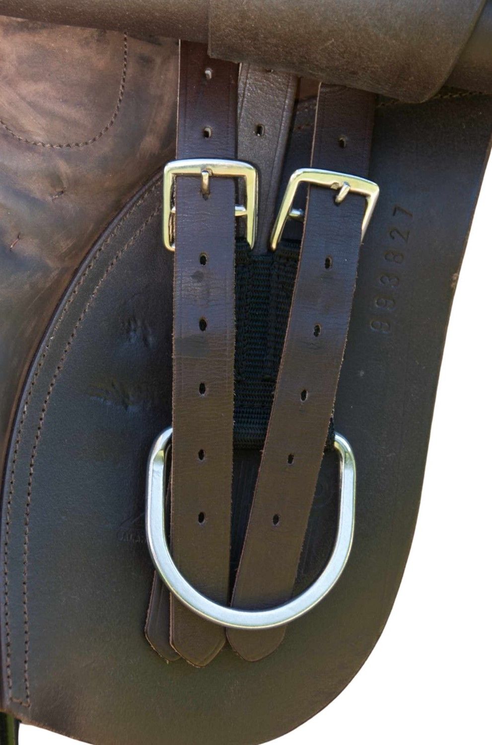 Braune Lederriemen mit silbernen Schnallen und D-Ring, an einem Sattel befestigt. Schwarzer Textilriemen.