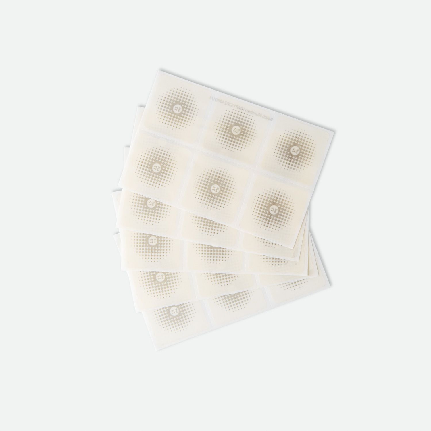 Mehrere quadratische Pflaster, gestapelt. Jedes Pflaster hat ein zentrales, rundes Muster.