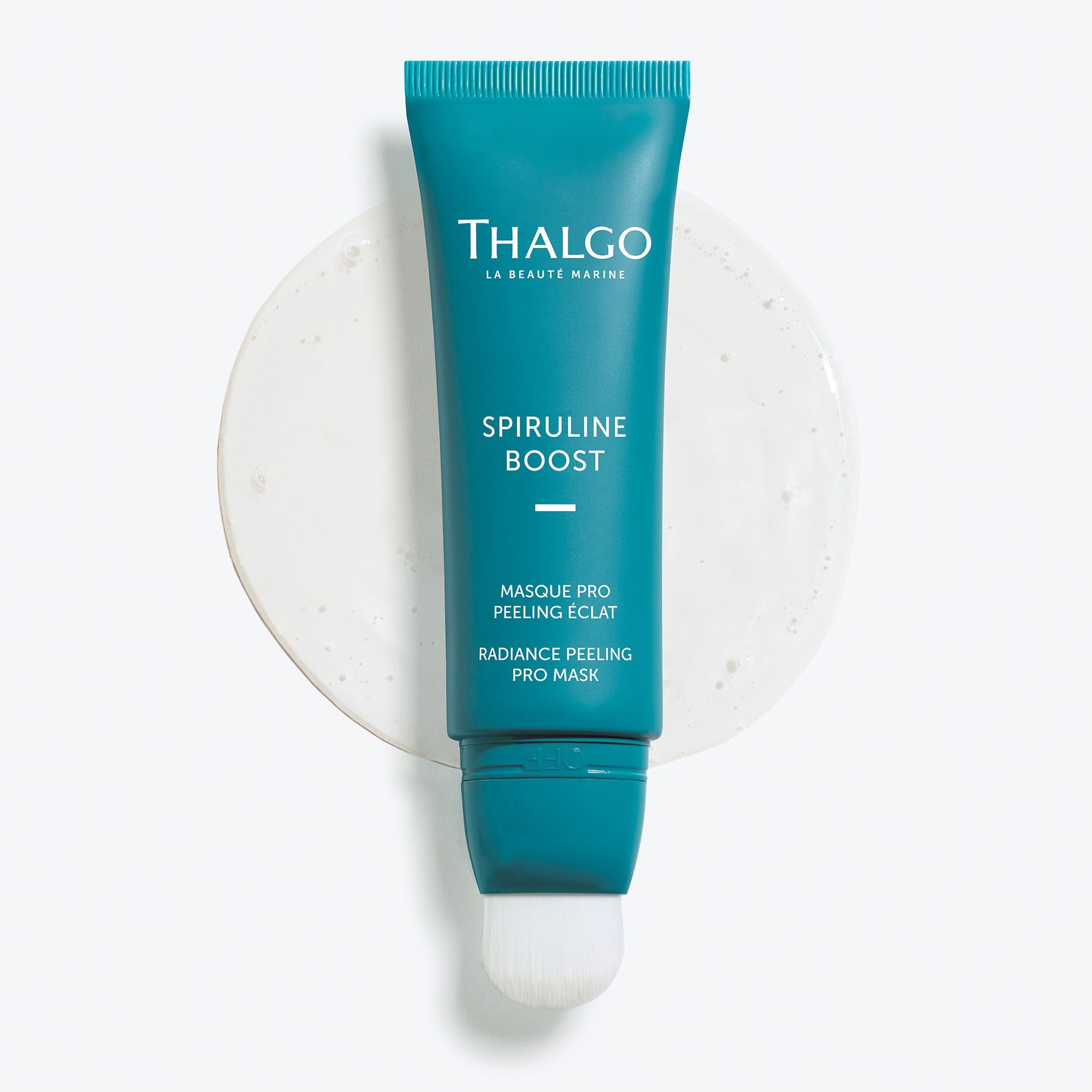 Türkisfarbene Tube mit weißem Pinsel. Aufschrift: THALGO, SPIRULINE BOOST, MASQUE PRO PEELING ÉCLAT, RADIANCE PEELING PRO MASK. Auf weißem Untergrund.
