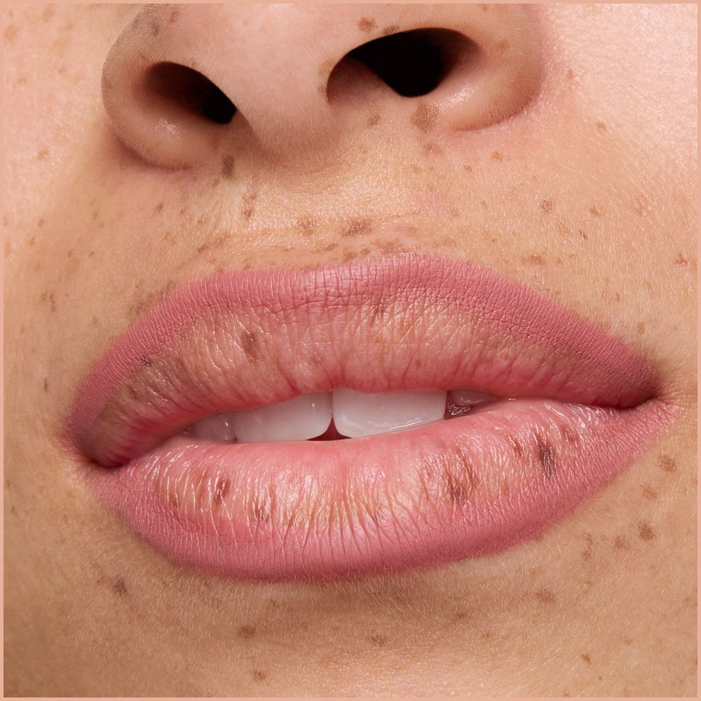 Nahaufnahme von Lippen, die mit Lippenstiftstift bemalt sind. Die Lippen sind rosa.