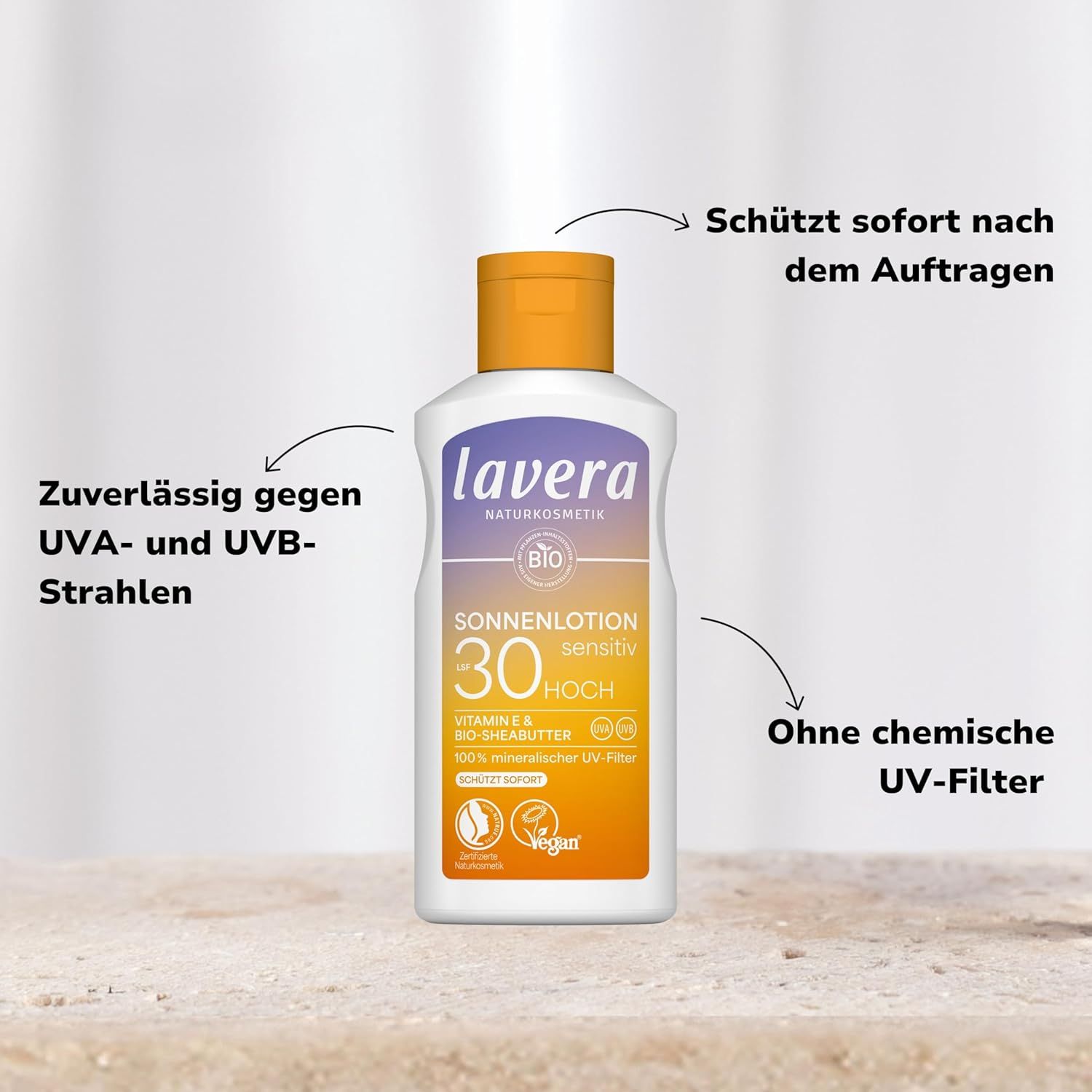 Sonnenlotion-Flasche, aufrecht. Text: lavera, Sonnenlotion Sensitiv LSF 30, BIO, Vegan. Pfeile zeigen auf Text.