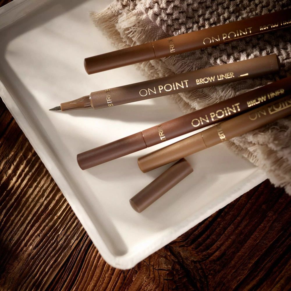Mehrere Augenbrauenstifte auf einem Tablett. Aufschrift: ON POINT BROW LINER. Verschiedene Farben.