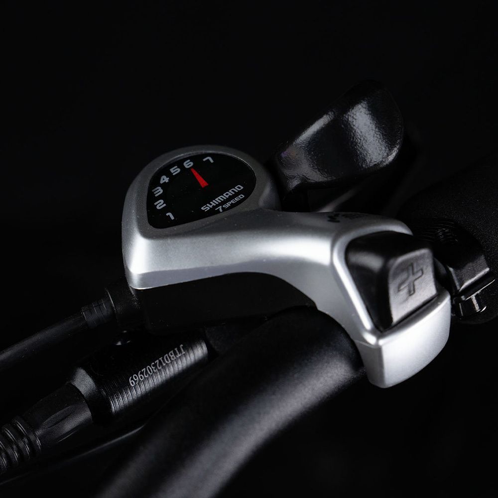 Schalthebel eines E-Bikes mit 7 Gängen. Marke Shimano sichtbar.