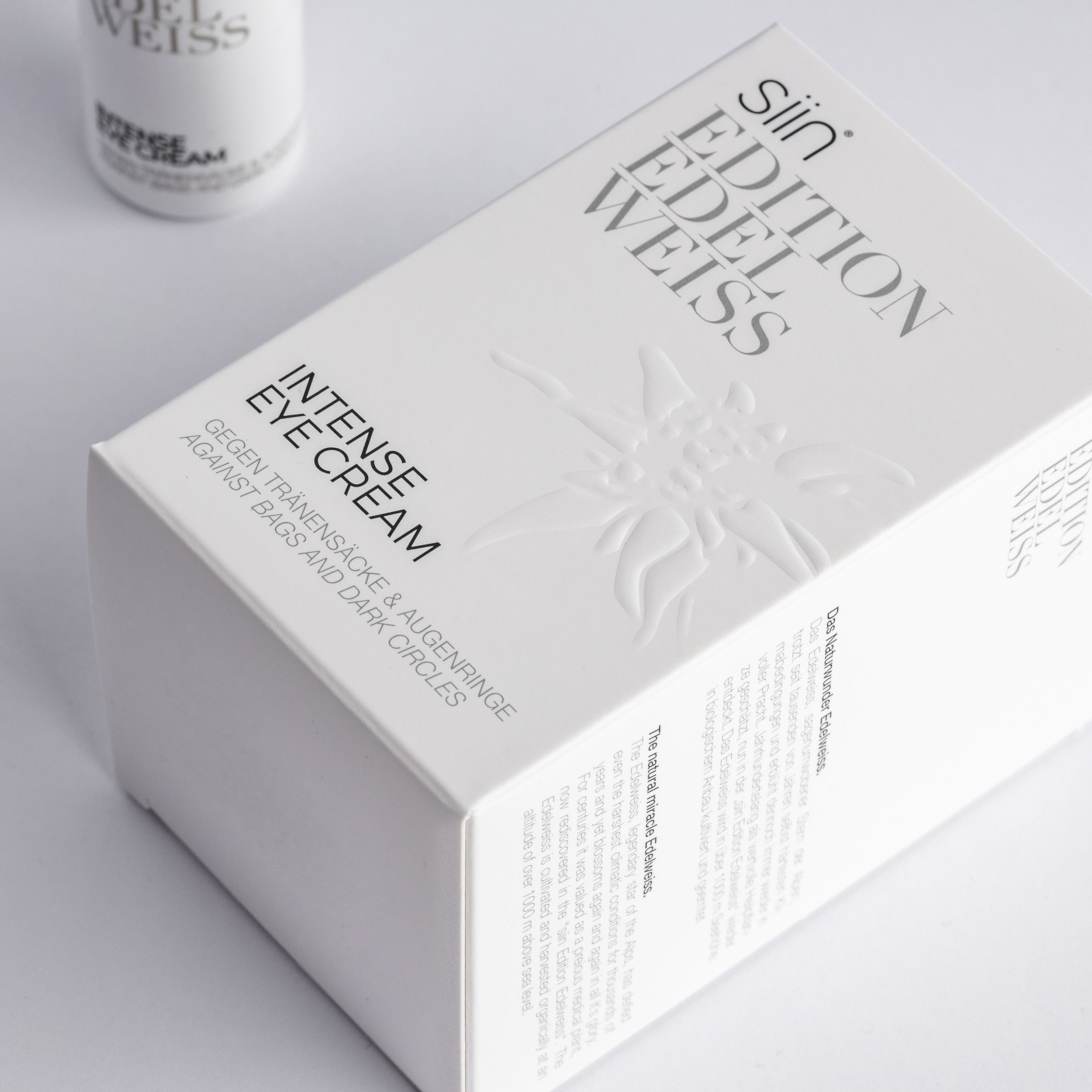 Weiße Produktverpackung mit Prägung und Schriftzug "siin Edition Edelweiss Intense Eye Cream". Text: Gegen Tränensäcke & Augenringe.