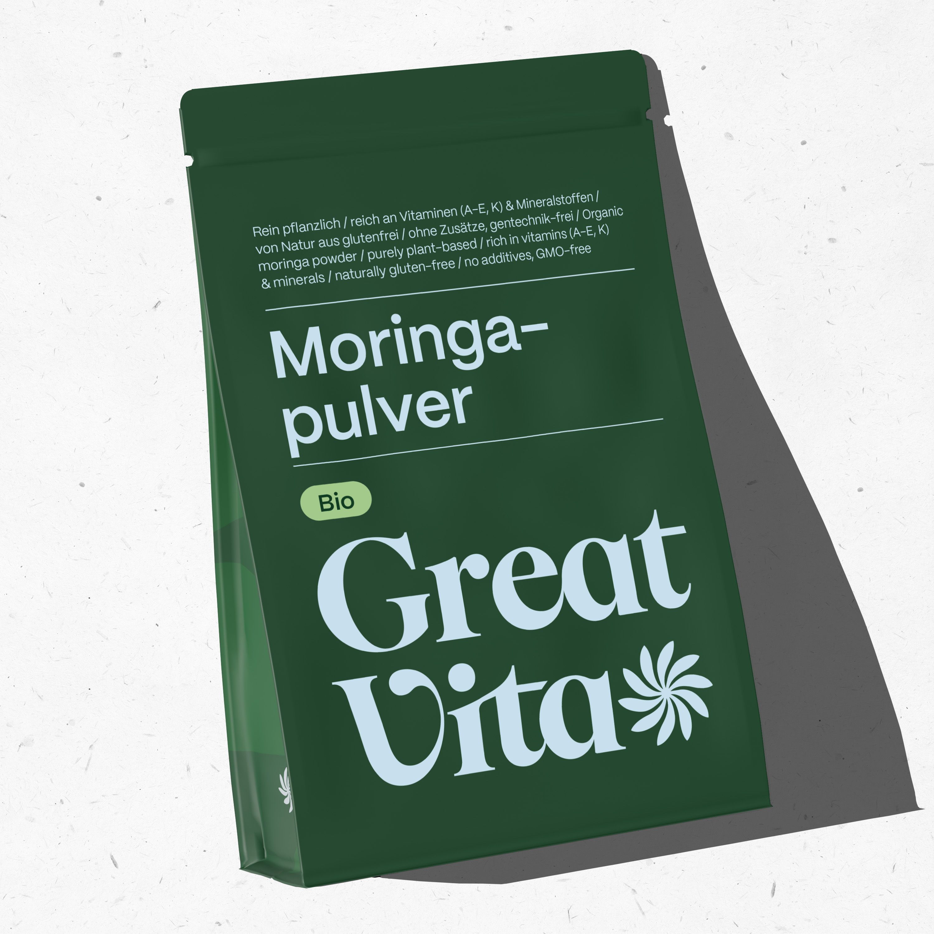 Grüner Beutel mit Text. Aufschrift: Moringa-Pulver Bio, Great Vita. Oben Text: Rein pflanzlich, reich an Vitaminen.