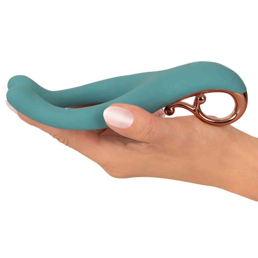 Türkisfarbenes Wellness-Produkt auf einer Handfläche. Ring und gebogene Enden sichtbar.