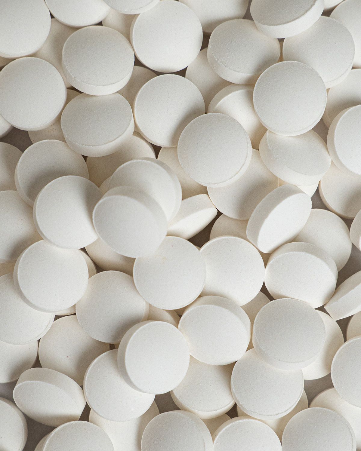 Nahaufnahme von vielen weißen Koffein-Tabletten.