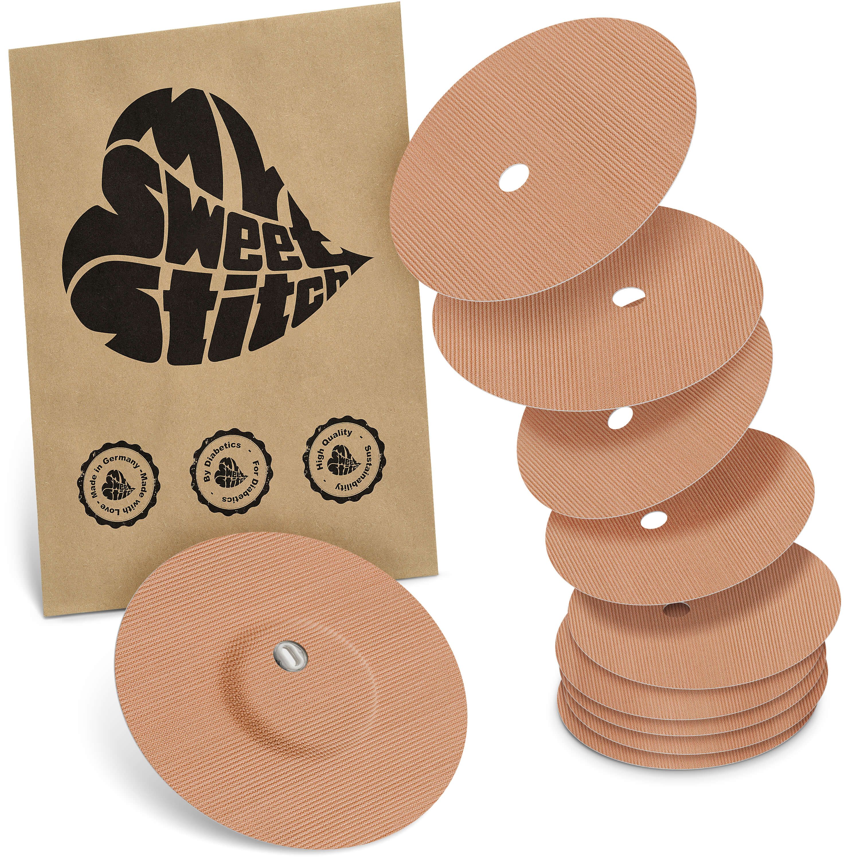 Beige Fixierpflaster mit Belüftungsloch. Mehrere Pflaster und eine braune Verpackung mit Logo und Siegeln.