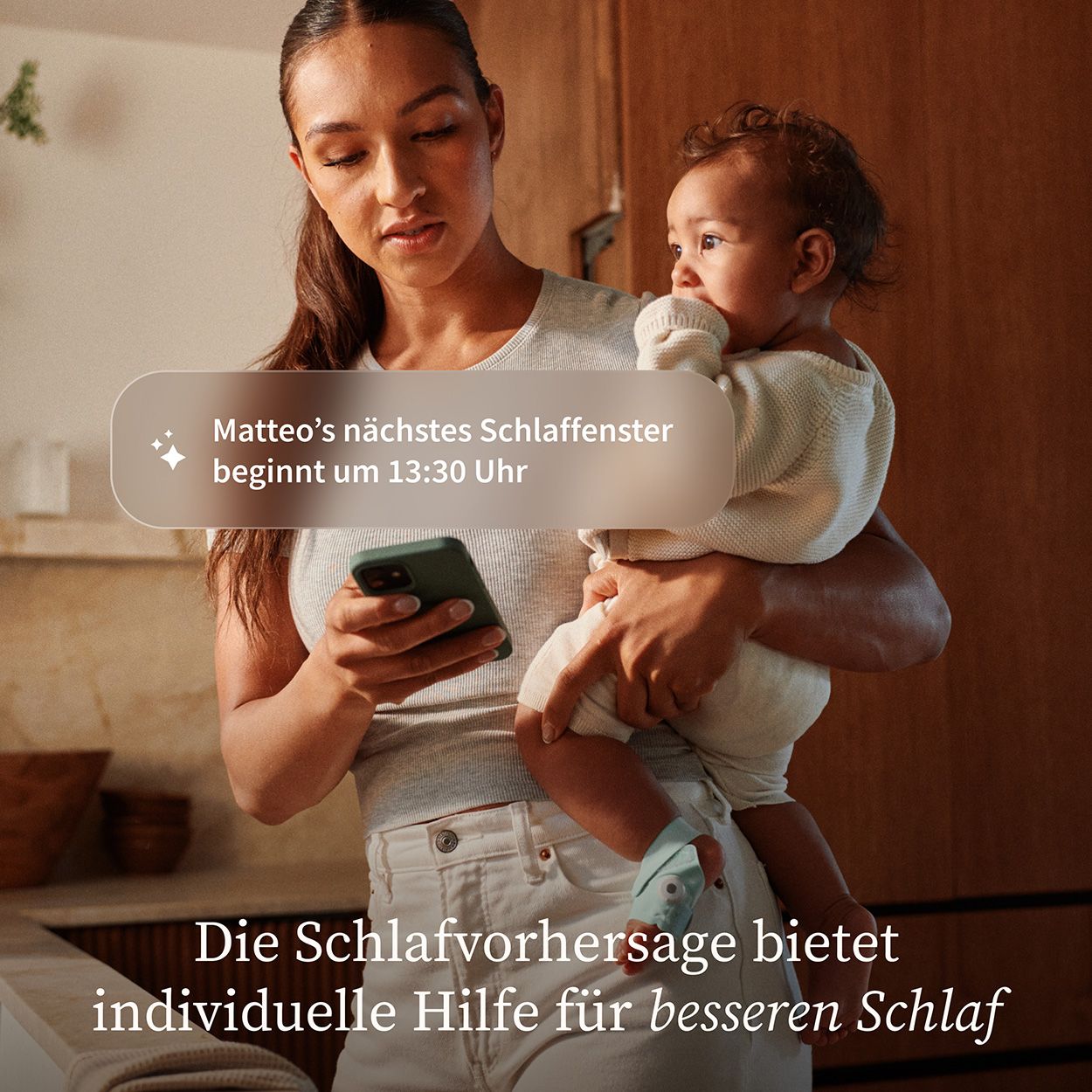 Frau hält Baby, schaut auf Smartphone. Text: Matteo's nächstes Schlaffenster beginnt um 13:30 Uhr. Text: Die Schlafvorhersage bietet individuelle Hilfe.