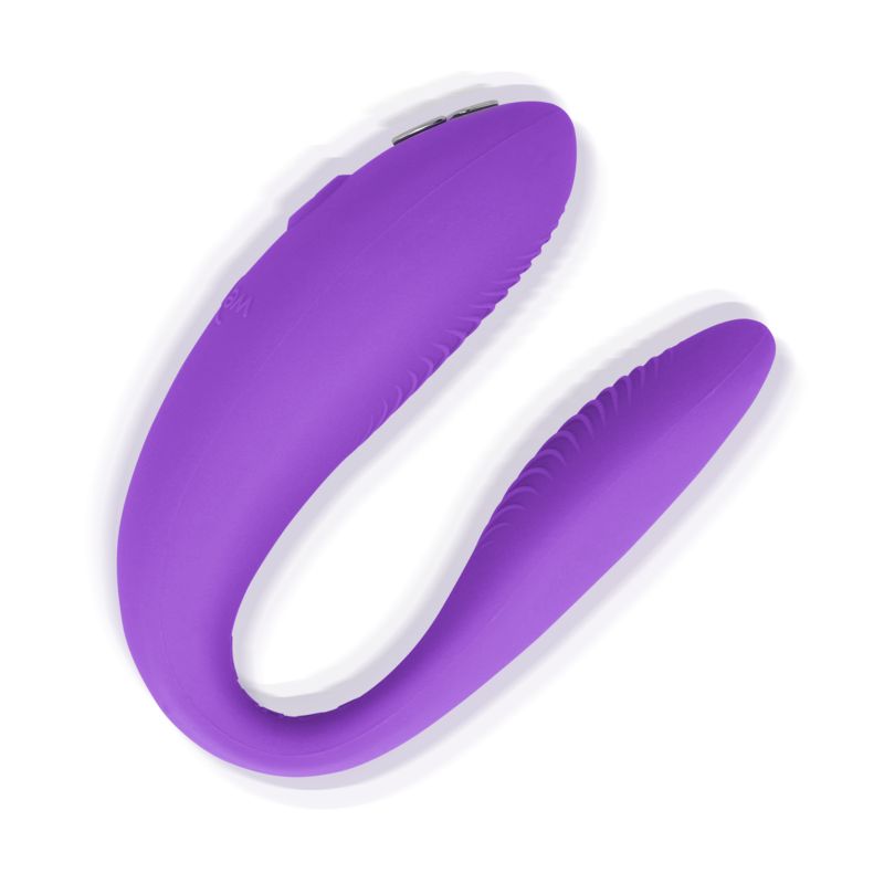 Lila Vibrator in U-Form. Oberflächen mit Rillen. Zwei Enden, verbunden. Auf weißem Hintergrund.