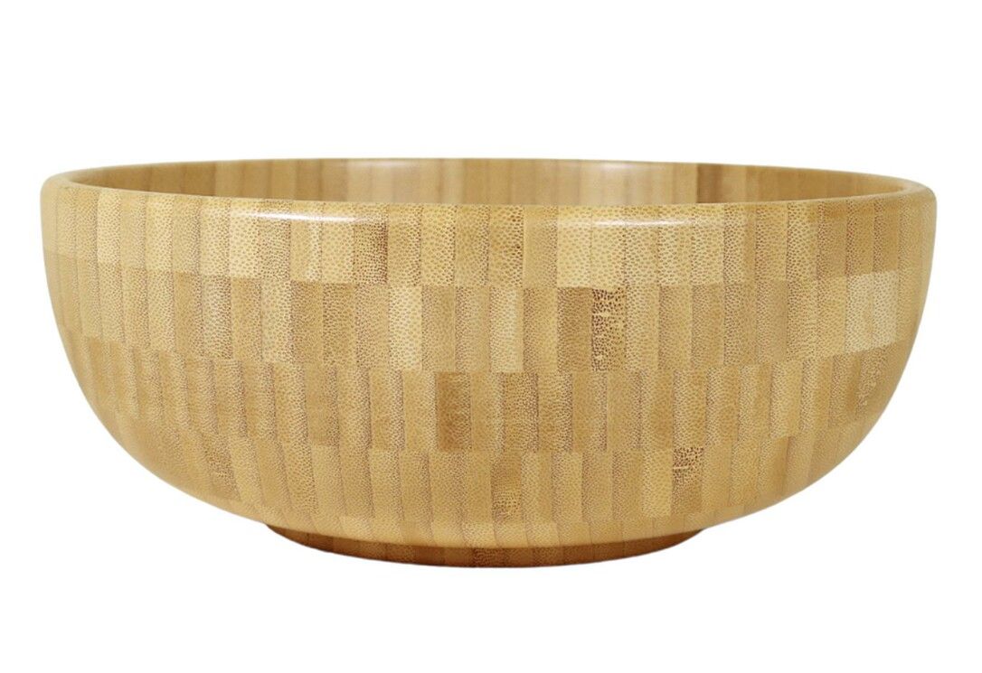 Runde Schüssel aus hellem Holz. Die Oberfläche ist aus kleinen Holzstücken zusammengesetzt. Die Schüssel hat eine abgerundete Form.