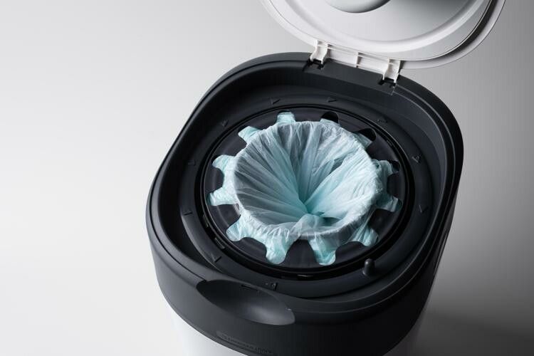 Nahaufnahme eines geöffneten Tommee Tippee Windeleimers mit einer blauen Folientüte im Inneren.