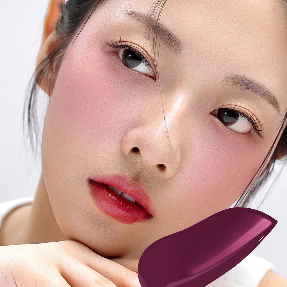 Nahaufnahme eines Gesichts mit Rouge auf den Wangen und Lippen. Auf den Lippen und als Swatch: Pflaumenfarbener Blusher.