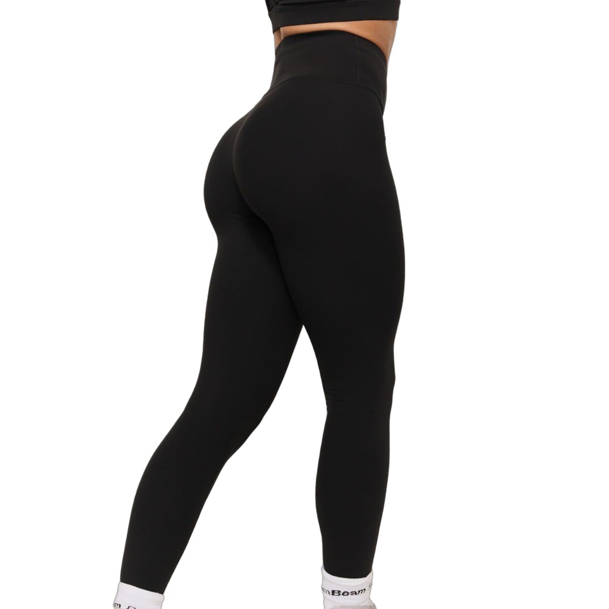Seitenansicht einer Frau in schwarzen Leggings mit hohem Bund, die ihre Form betonen.