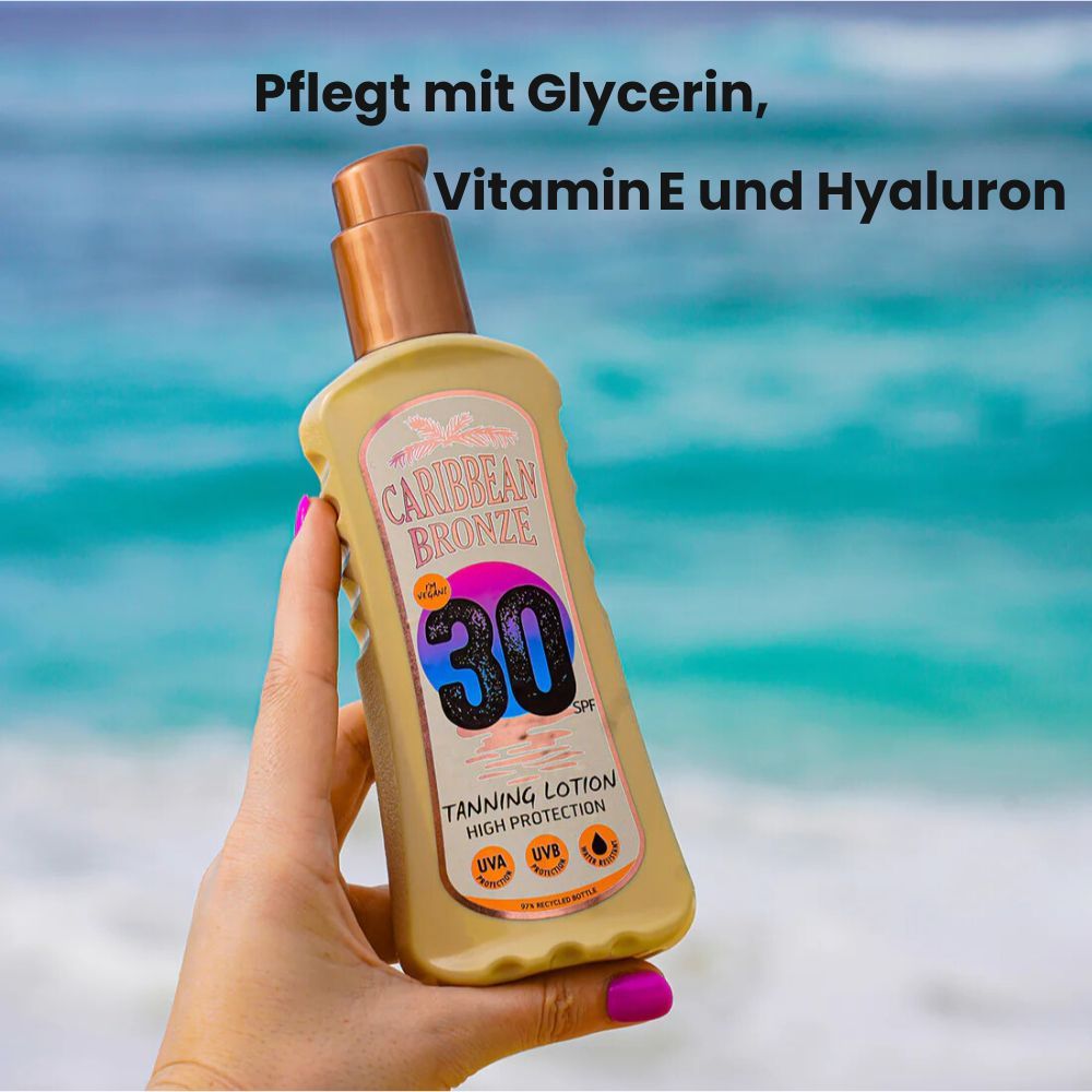 Hand hält Sonnenlotion-Flasche. Aufschrift: Caribbean Bronze, 30 SPF, Tanning Lotion. Text: Pflegt mit Glycerin, Vitamin E und Hyaluron.