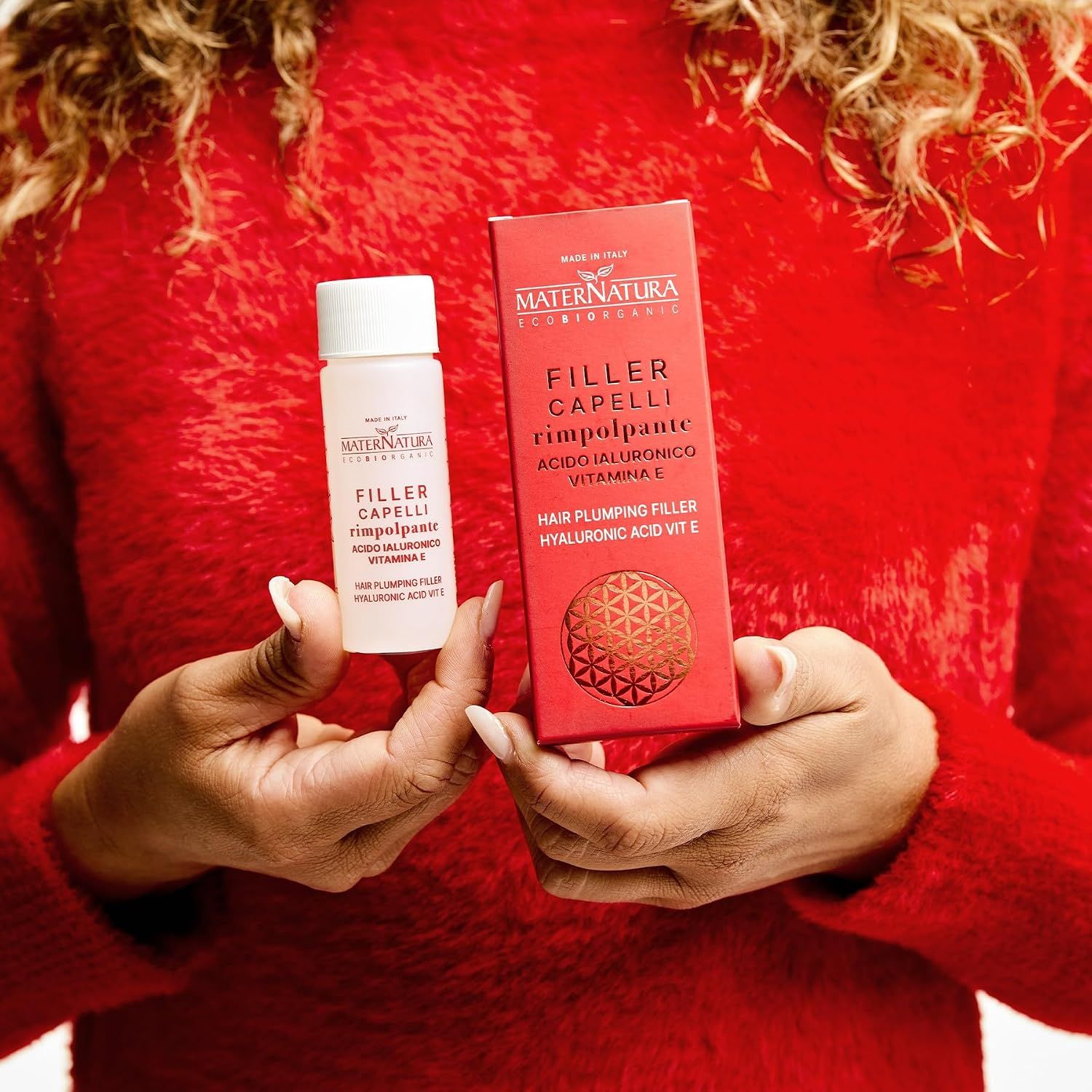 Frau mit langen Haaren hält Maternatura Hair Filler Box. Enthält Hyaluronsäure und Vitamin E.