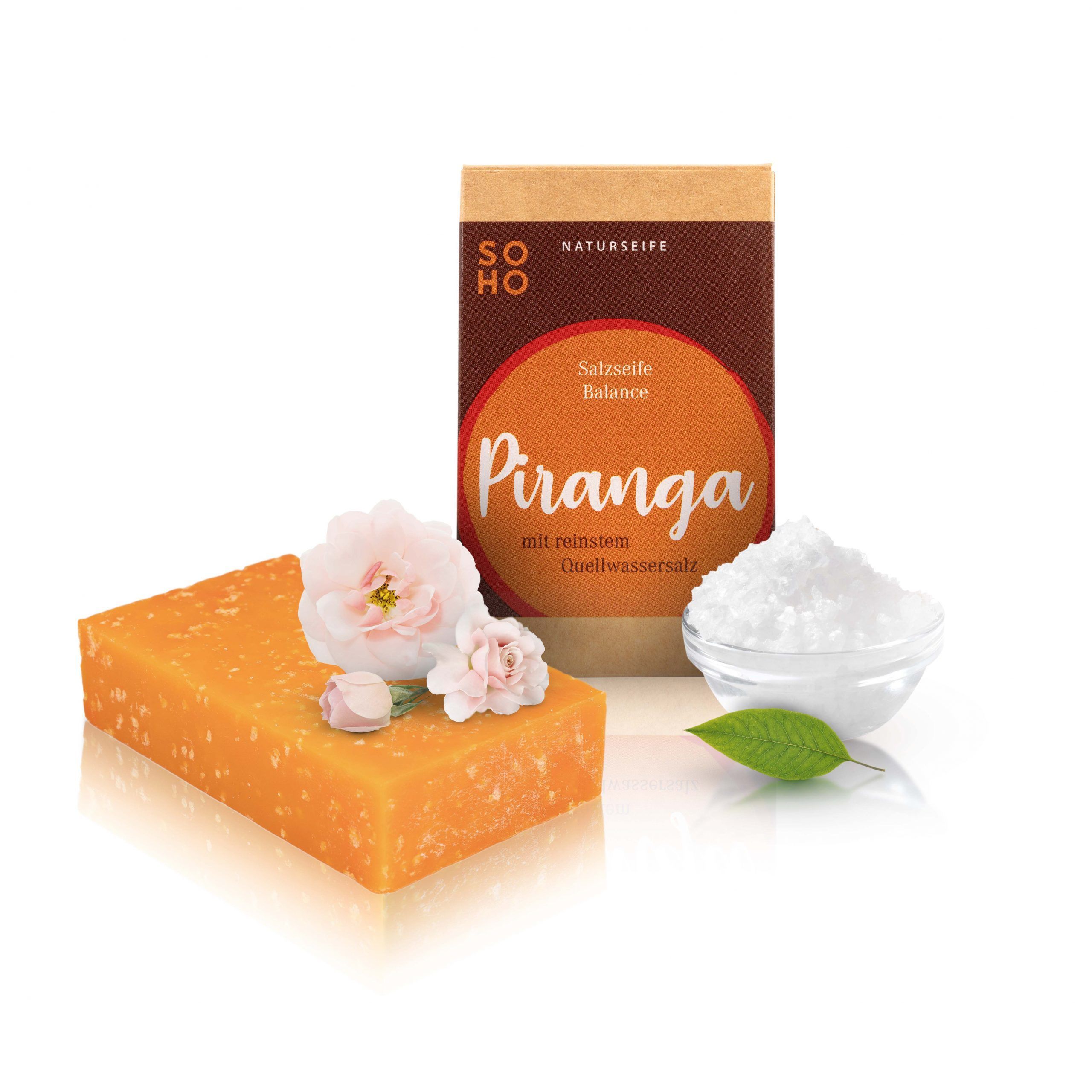 Seife, Verpackung, Blüten und Salz. Verpackung mit Logo und Produktnamen 'PIRANGA'. Salz in Schale. Blüten.