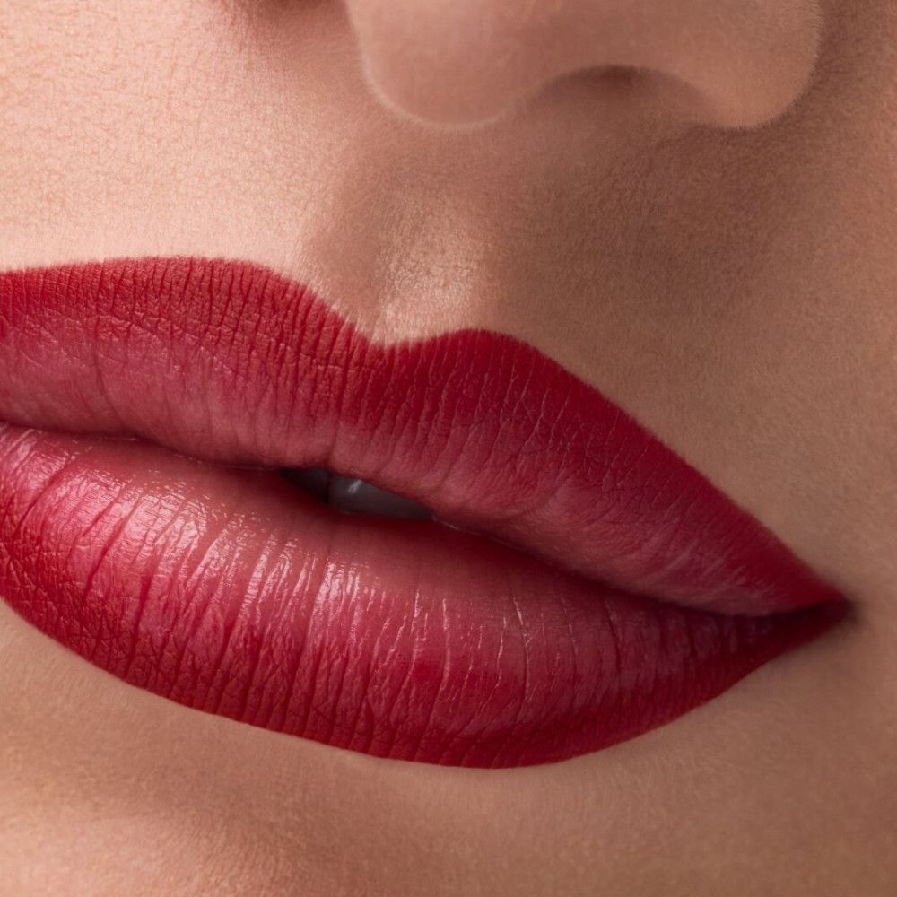 Nahaufnahme von Lippen mit rotem Lippenstift. Die Lippen sind geschminkt.