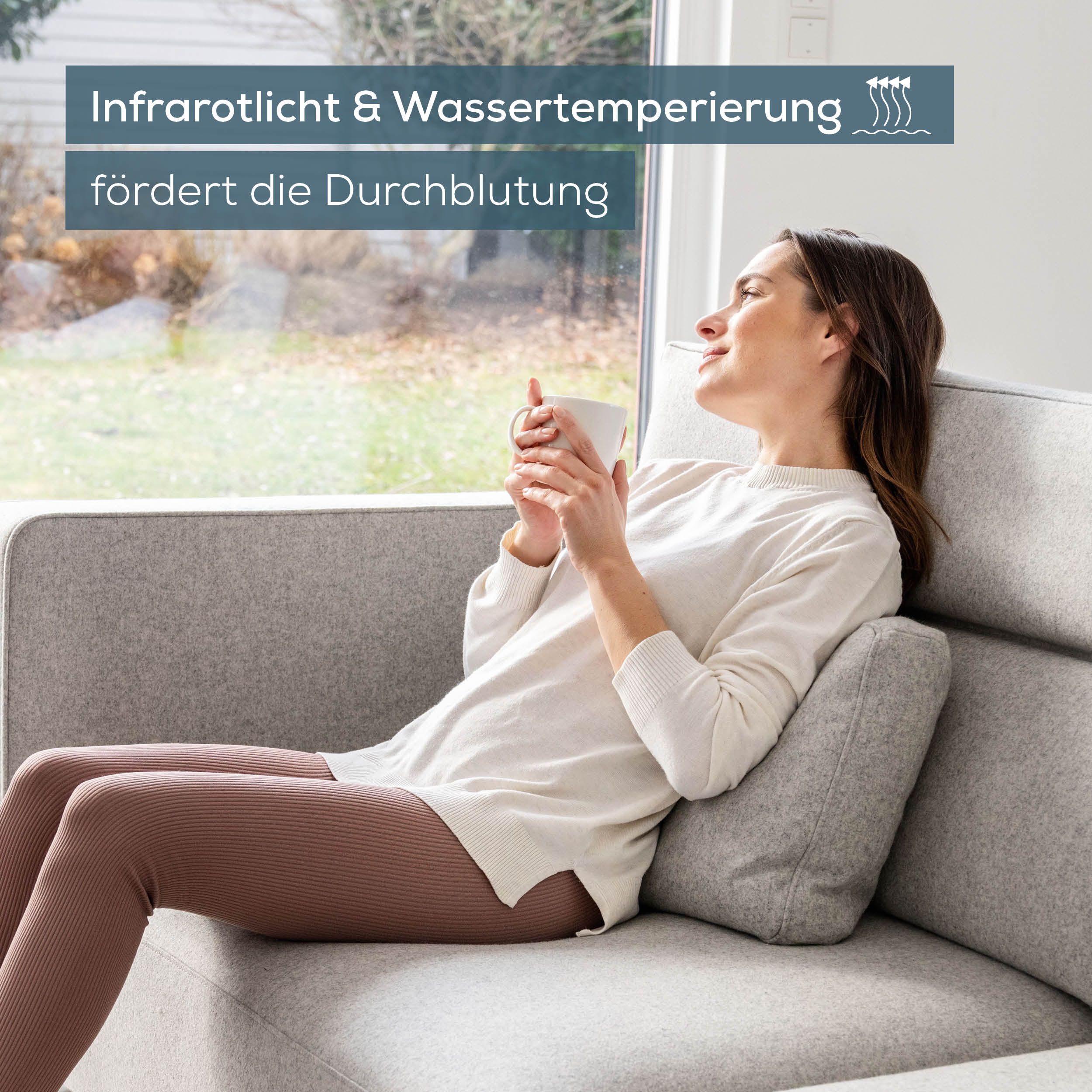 Frau sitzt auf Sofa. Text: Infrarotlicht & Wassertemperierung fördert die Durchblutung. Frau hält Tasse.