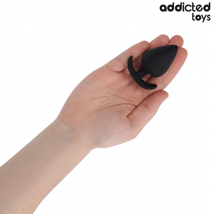 Schwarzer Analplug in einer Hand gehalten. Tropfenförmiger Kopf, gebogene Basis. Marke: Addicted Toys.