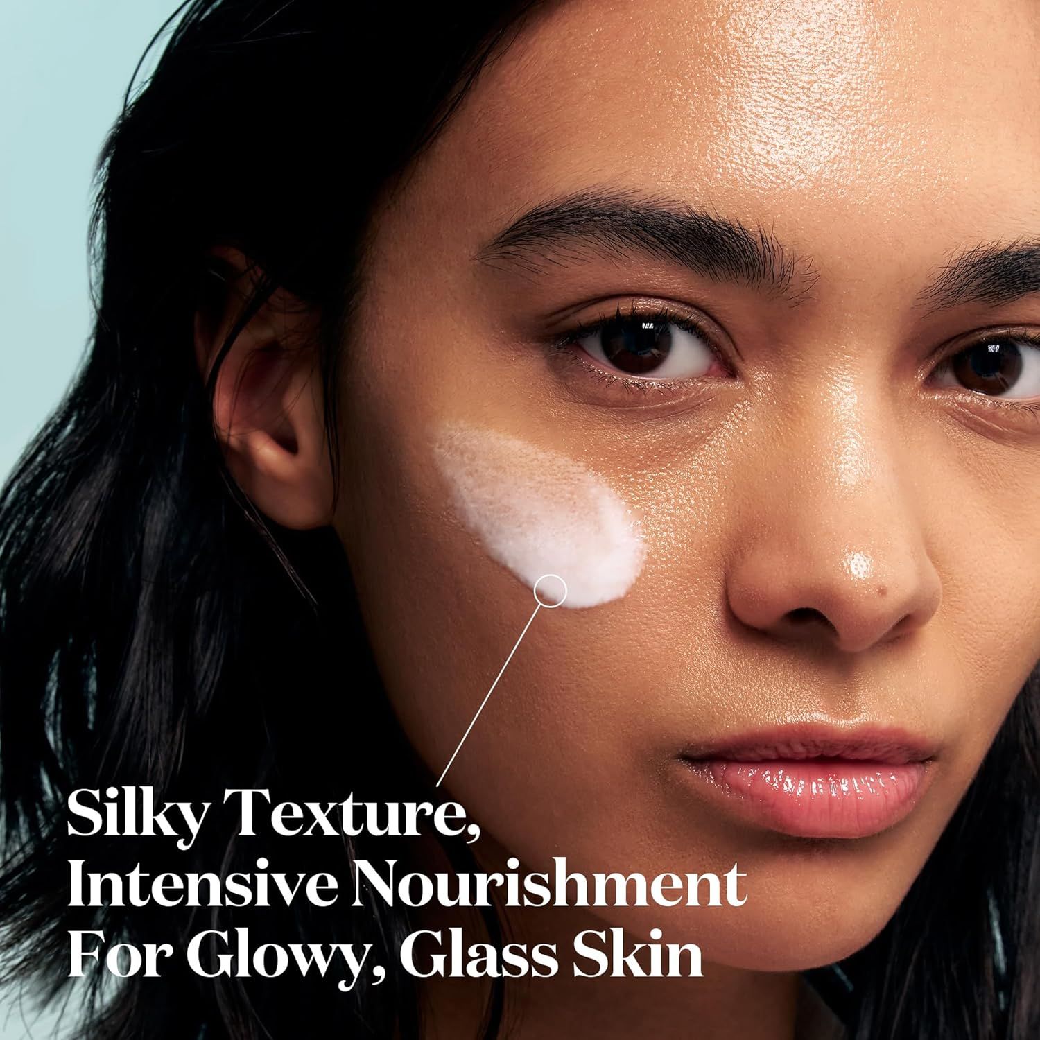 Nahaufnahme eines Gesichts mit aufgetragener weißer Flüssigkeit. Text: Silky Texture, Intensive Nourishment For Glowy, Glass Skin.