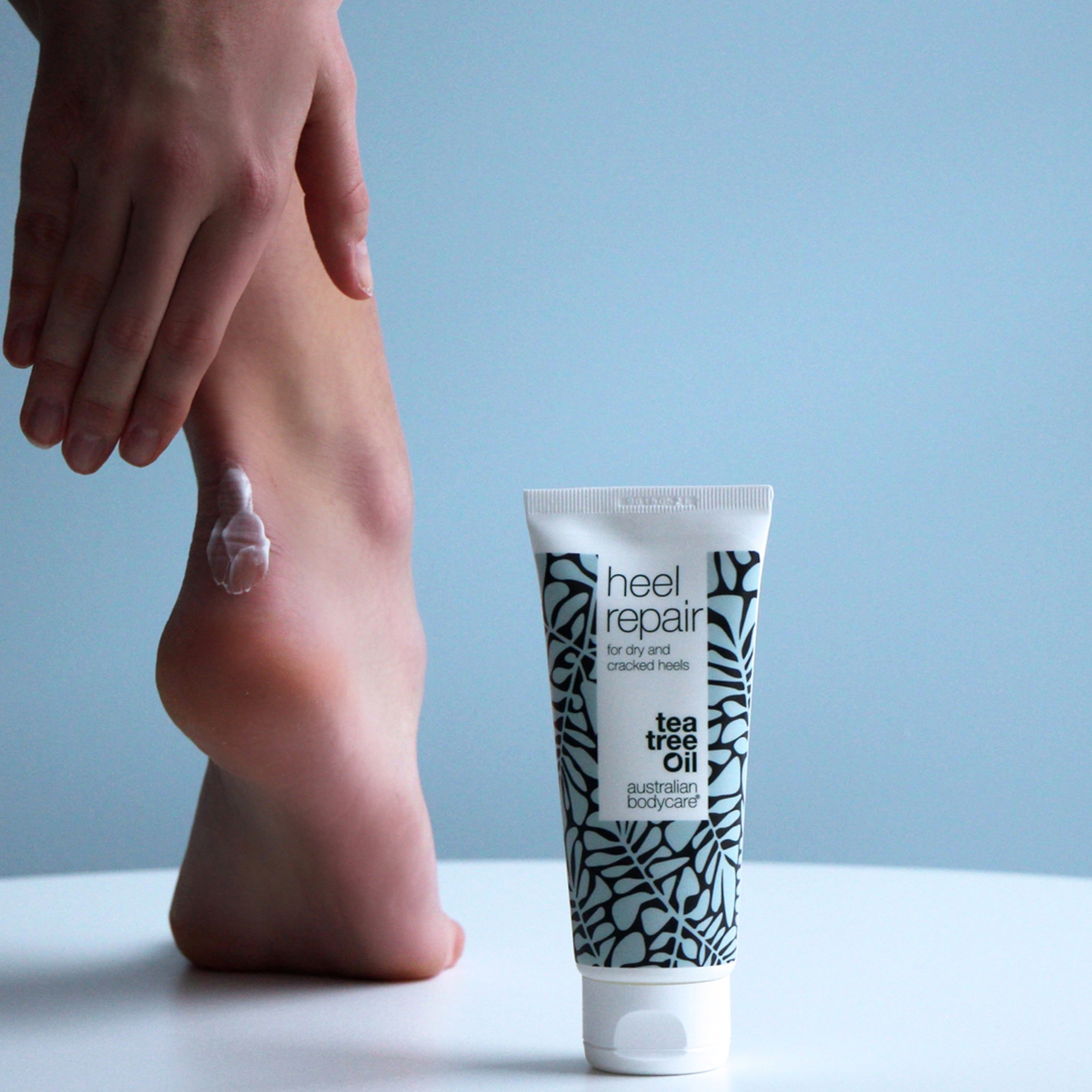 Person trägt Creme auf Ferse auf. Tube Heel Repair, Tea Tree Oil, Australian Bodycare.