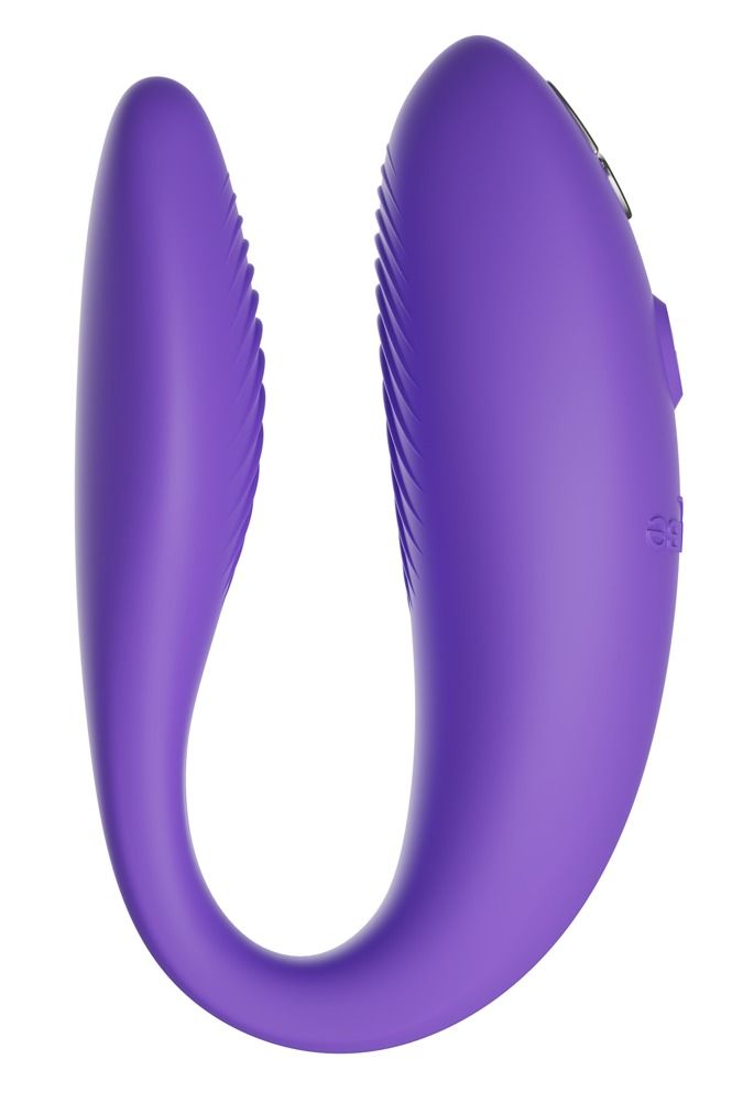 Lila Vibrator in U-Form. Oberflächen mit Rillen. Knöpfe an der Oberseite. Auf weißem Hintergrund.