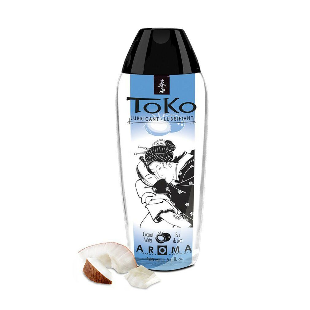 ToKo Aroma Kokoswasser Gleitmittel in transparenter Flasche mit schwarzem Verschluss. Kokosnussstücke daneben.