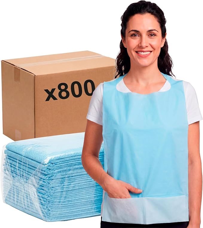 Frau trägt ein blaues Einweg-Lätzchen, daneben ein Karton mit der Aufschrift "x800" und gestapelte Lätzchen.