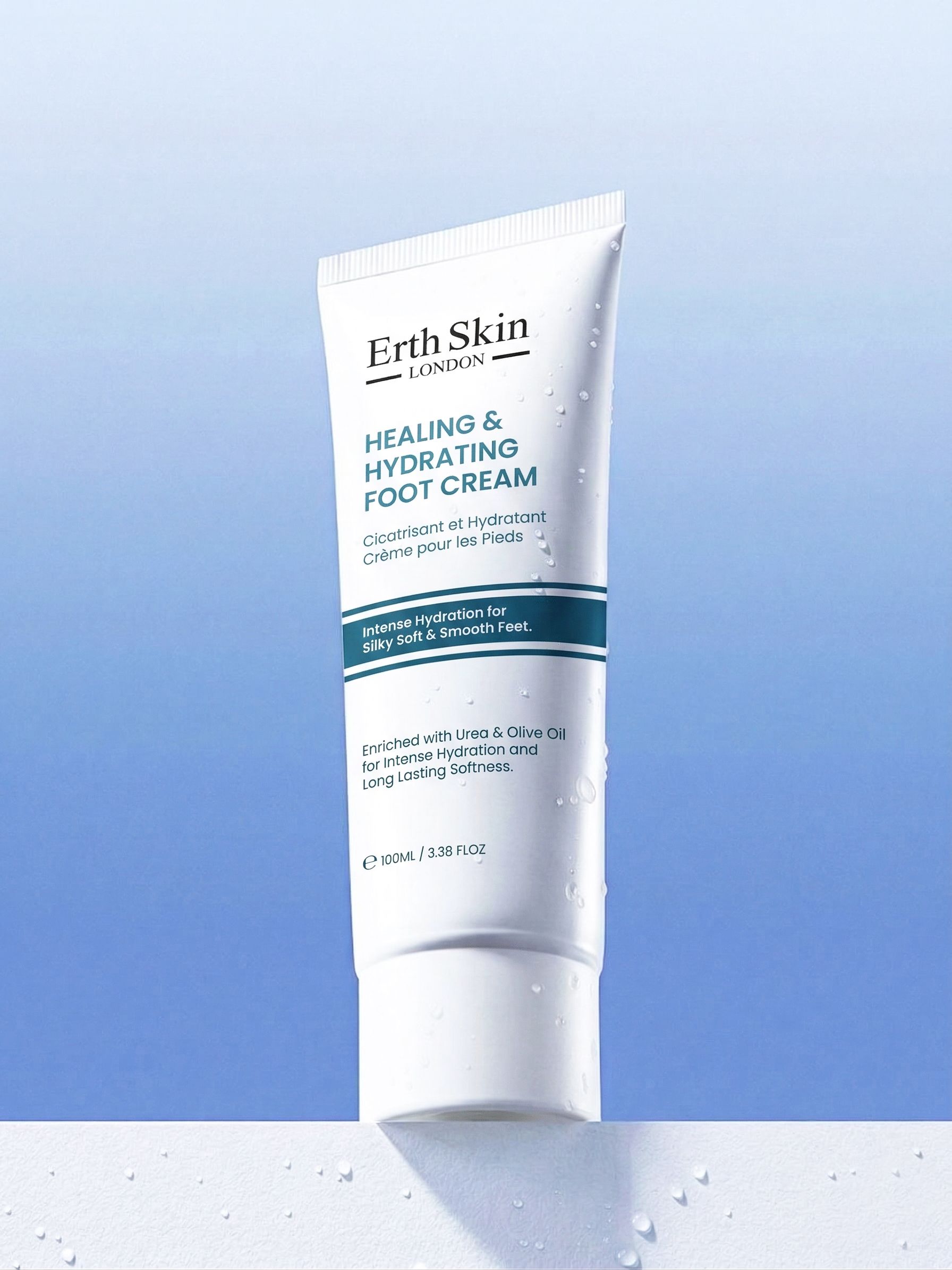 Weiße Tube Erth Skin London Heilende und feuchtigkeitsspendende Fußcreme auf blauem Hintergrund mit Wassertropfen.