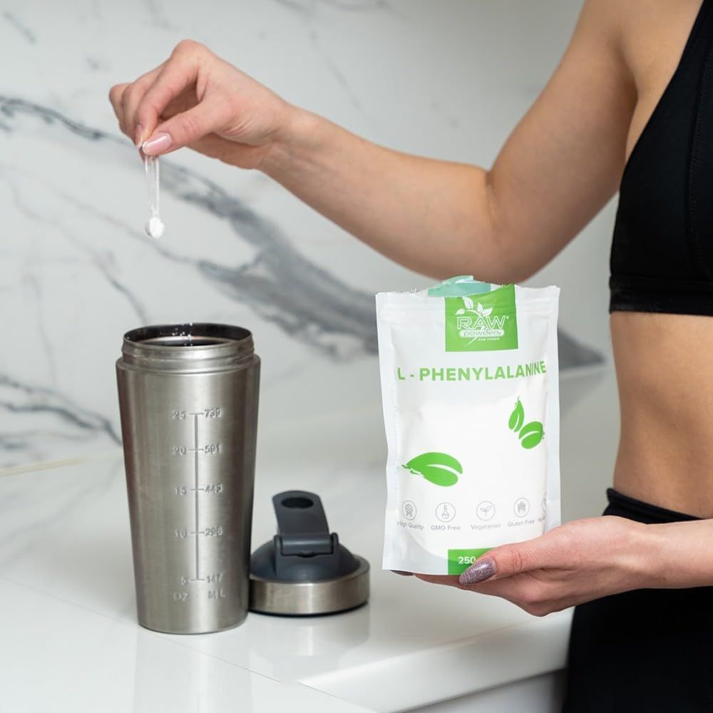 Frau bereitet L-Phenylalanin Pulver mit einem Shaker zu.