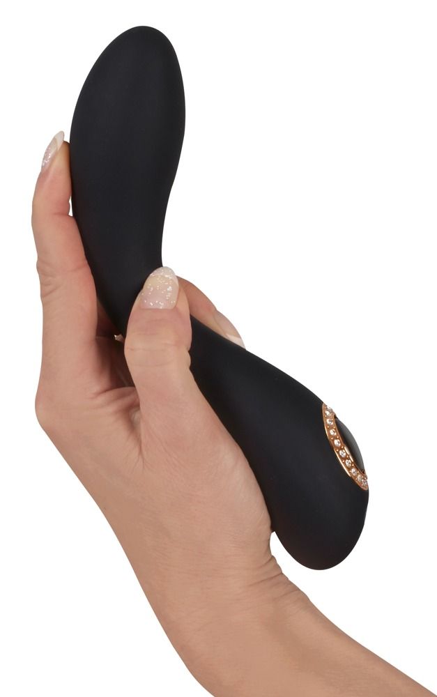 Schwarzer Vibrator in einer Hand gehalten. Ergonomische Form, ovales Detail mit Schmucksteinen.