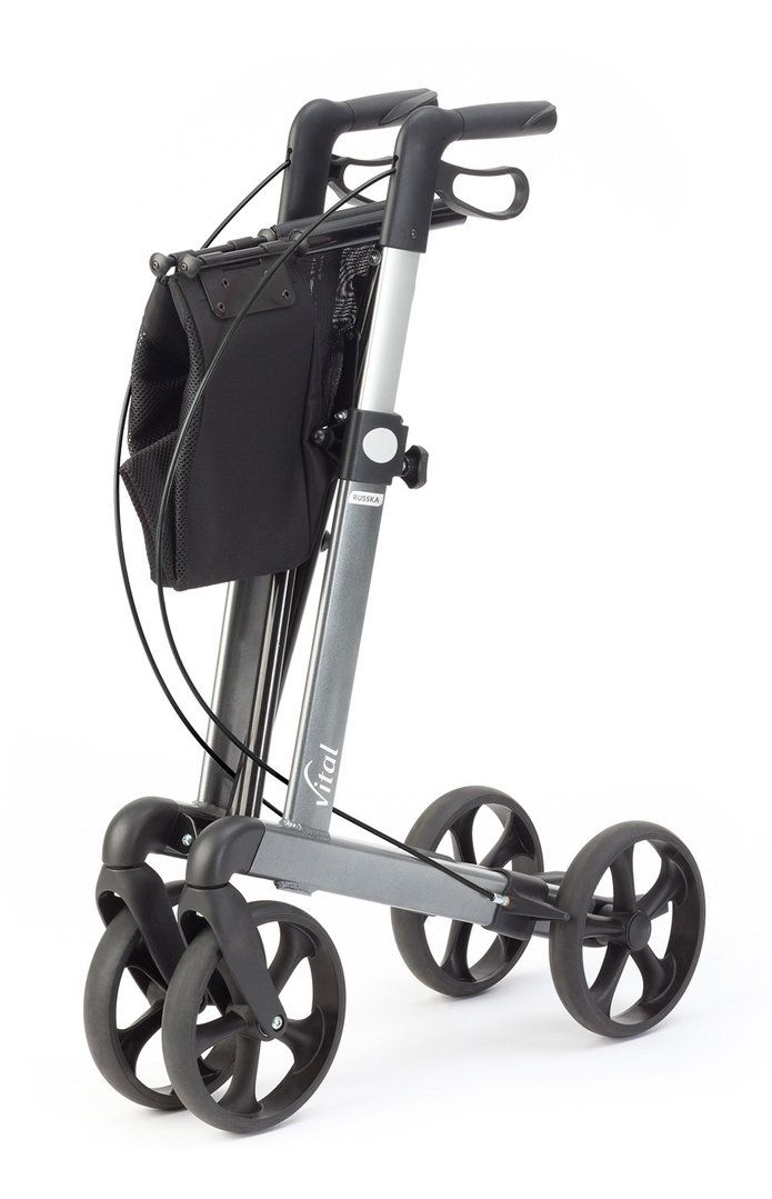Gefalteter grauer Rollator mit vier Rädern. Schwarzer Korb. Vital-Schriftzug. Höhenverstellbare Griffe.