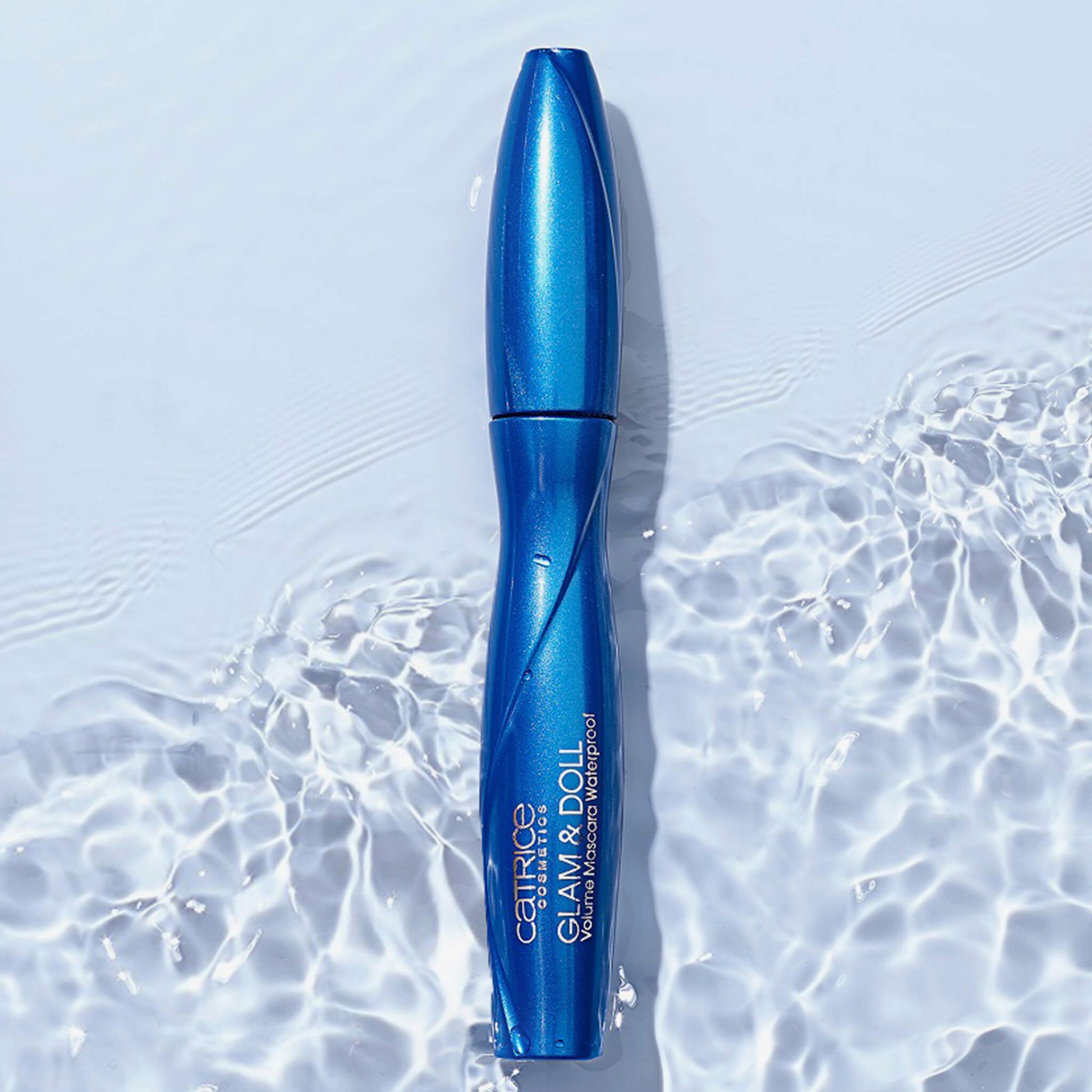 Blaue Mascara-Tube im Wasser. Aufschrift: Catrice Glam & Doll Volume Mascara Waterproof.