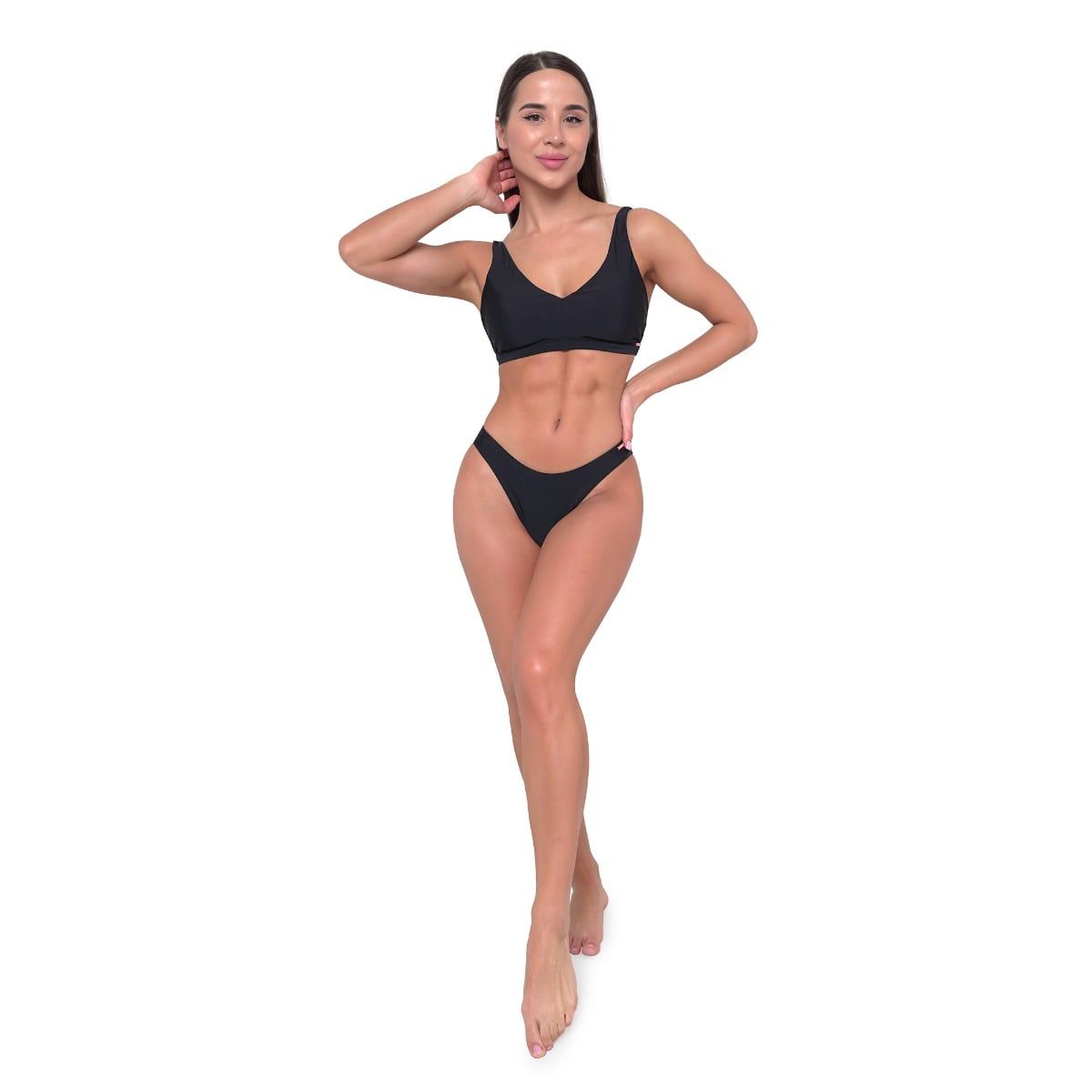 Ganzkörperansicht einer Frau in schwarzem Bikini-Oberteil und Unterteil, stehend.