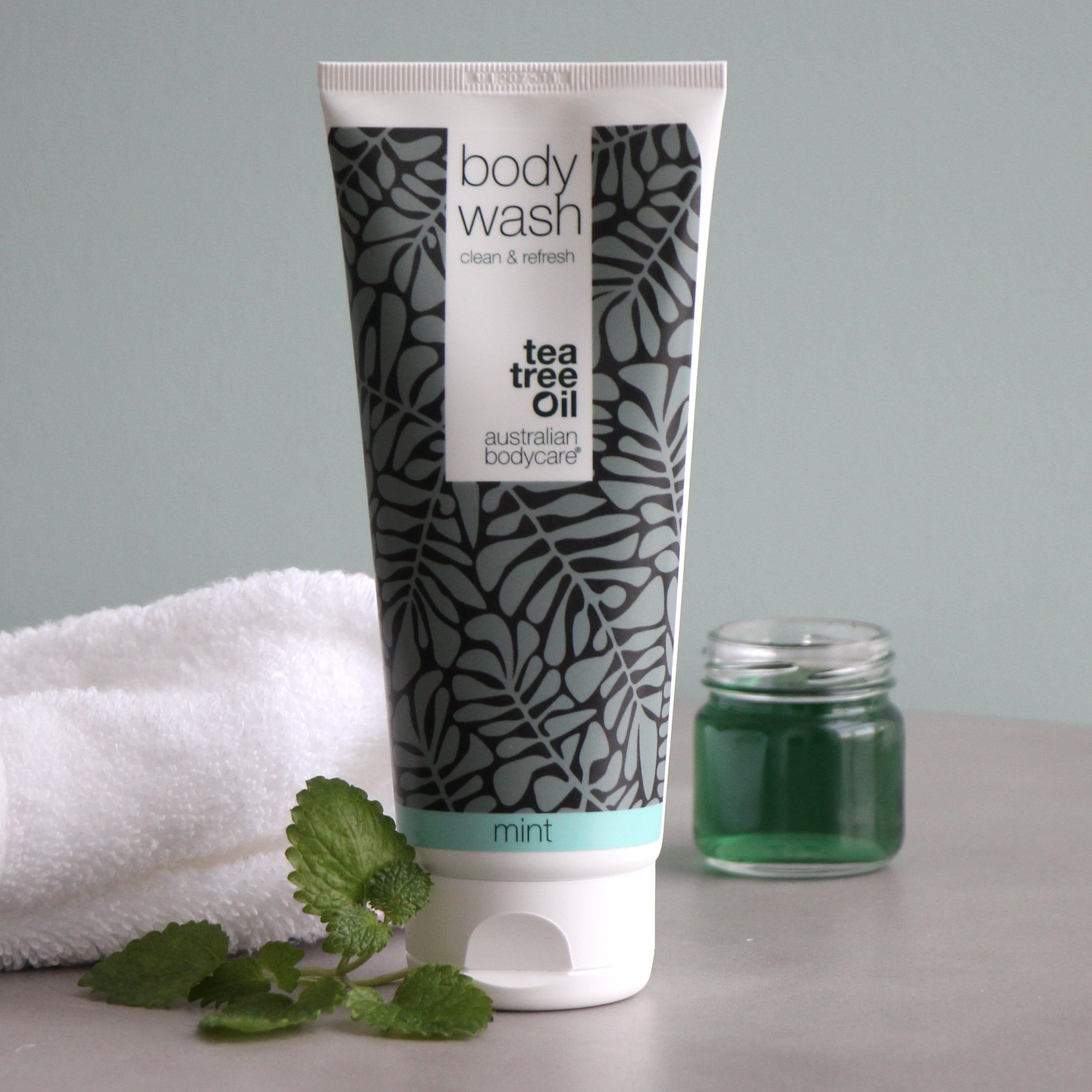 Tube mit „body wash“ und „australian bodycare“ Schriftzug. Daneben ein Glas mit grüner Flüssigkeit.