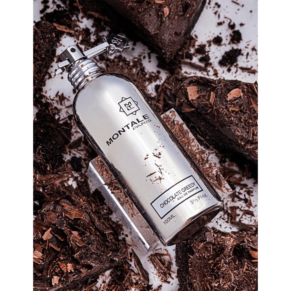 Silberne Parfumflasche Chocolate Greedy auf Schokoladenstückchen. Aufschrift Montale Paris.