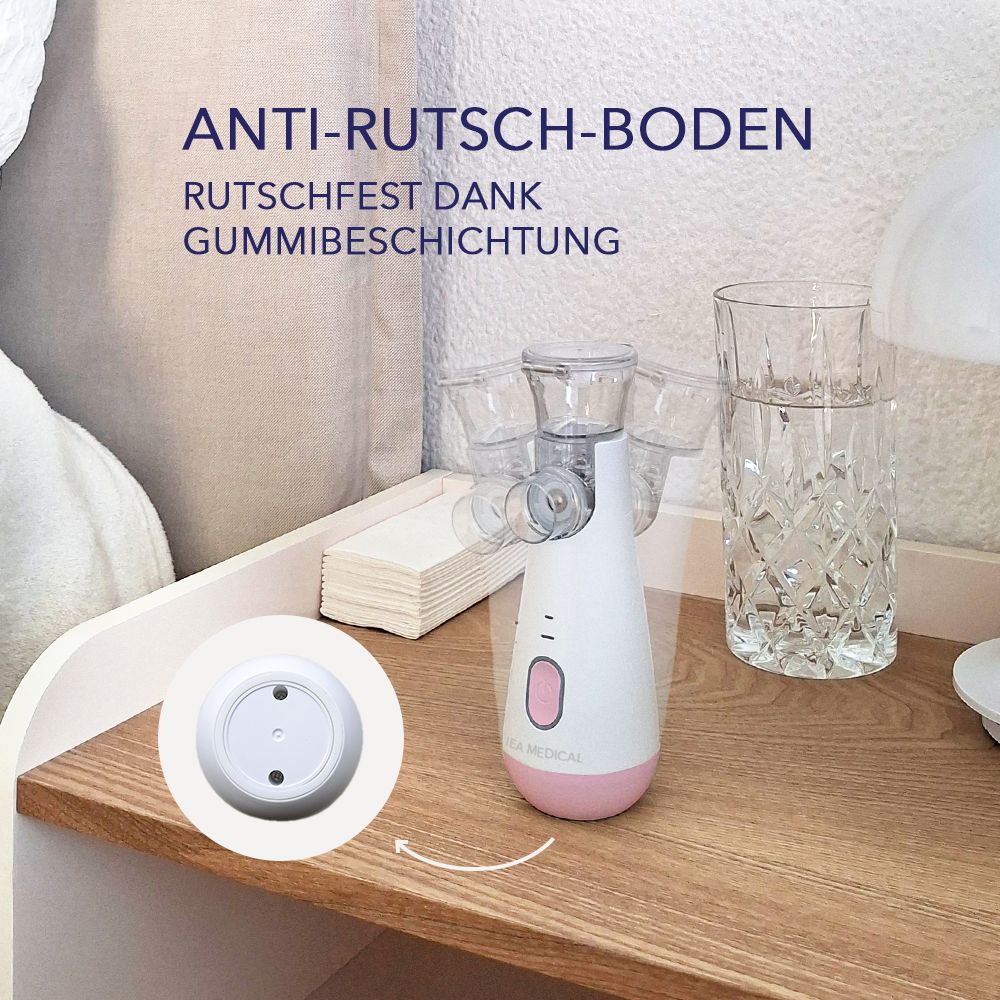 Weißer Inhalator mit rosa Boden auf Nachttisch, mit Gummibeschichtung.