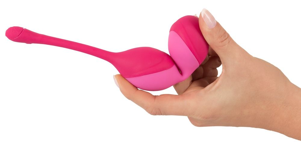 Rosa Duo-Vibrokugel in Hand gehalten. Produkt liegt auf weißem Hintergrund.