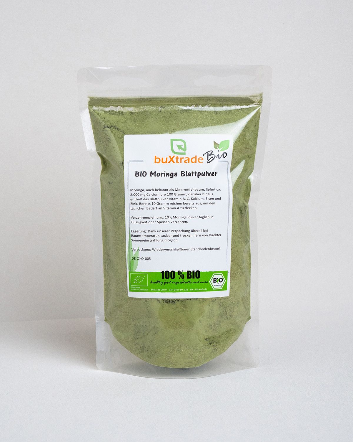 Transparenter Beutel mit buXtrade Bio Moringa Blattpulver. Produktinformationen und Bio-Siegel.