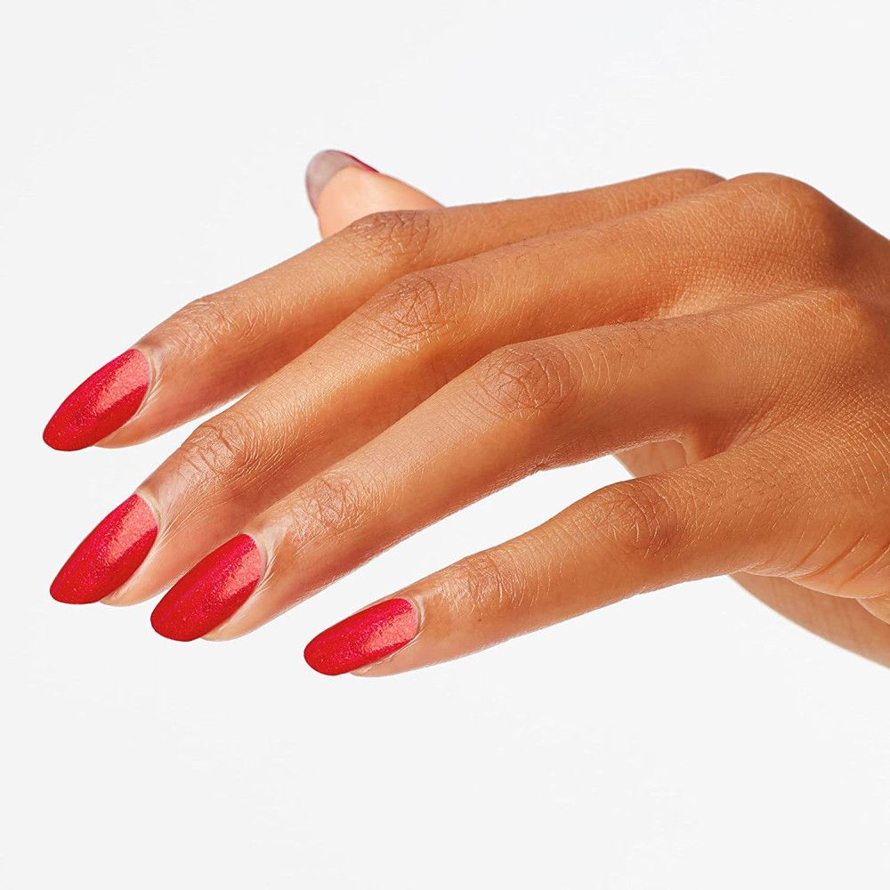 Hand mit lackierten Nägeln. Roter Nagellack mit Glitzer.