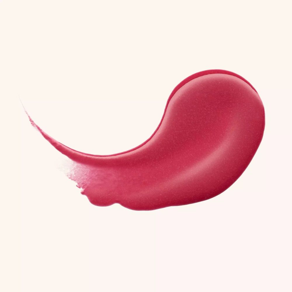 Ausgestrichene, glänzende Lippenbalsam-Probe. Farbton: Rosa. Auf hellem Hintergrund.