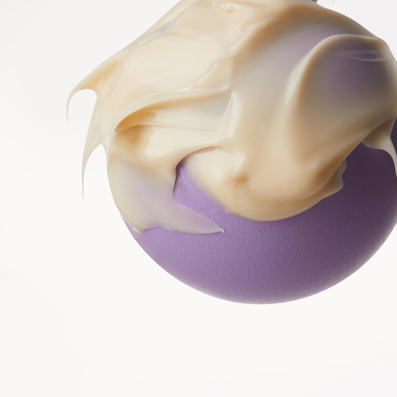 Cremige Textur der Belif Youth Creator Age Knockdown V Cream auf einer violetten Kugel.
