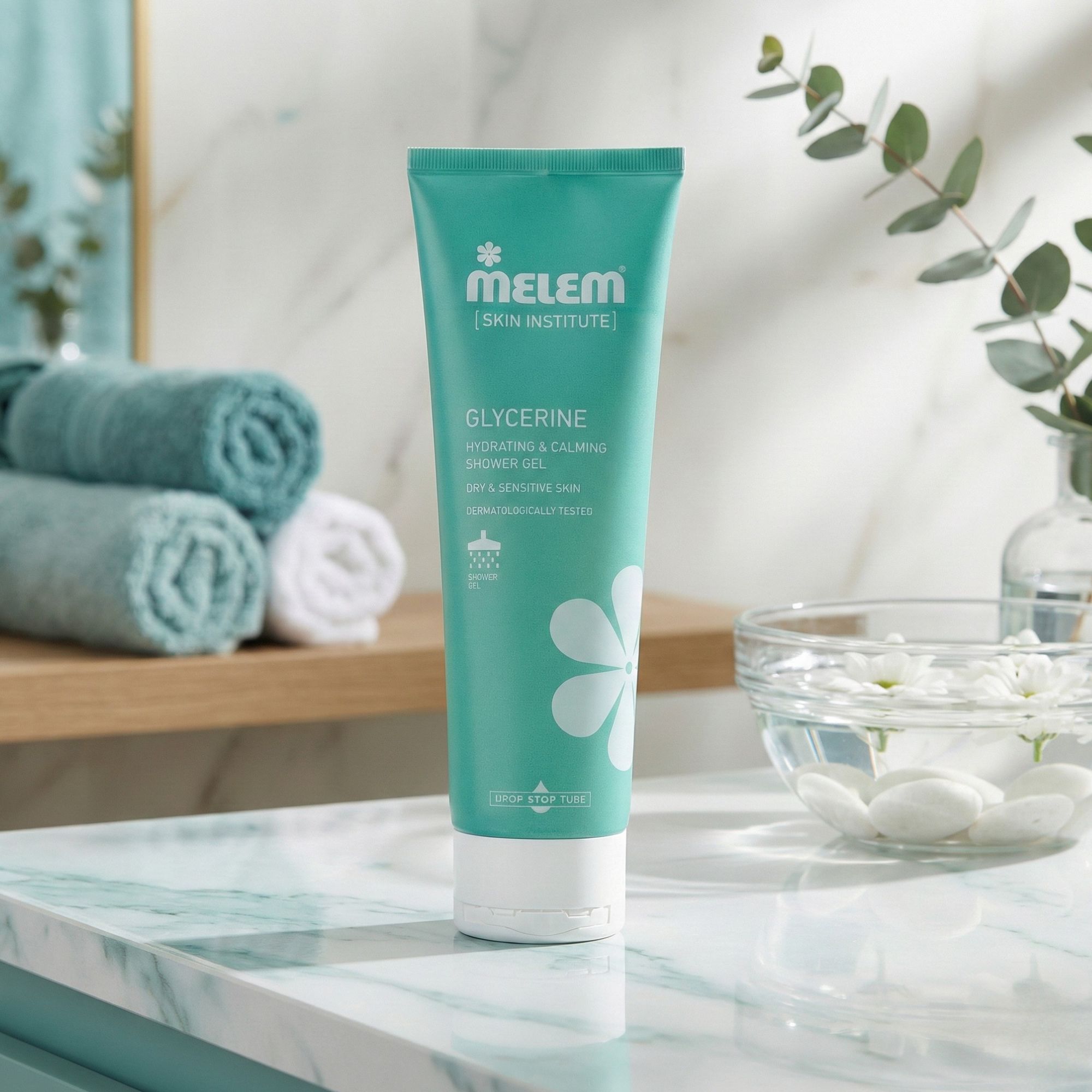 Türkisgrüne Tube mit weißem Verschluss. Aufschrift: Melem, Glycerine, Hydrating & Calming Shower Gel. Steht auf einer Marmoroberfläche.