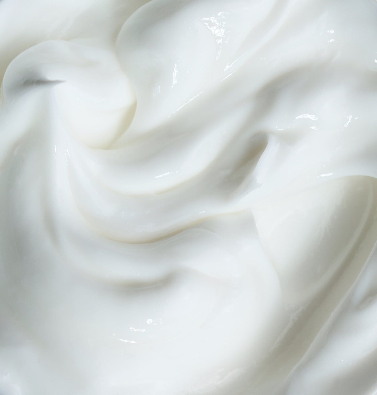 Nahaufnahme von weißer Creme. Cremige Textur, gewirbelt.